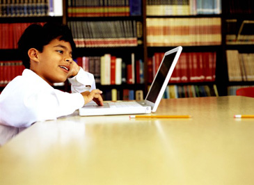 Boy using computer in library