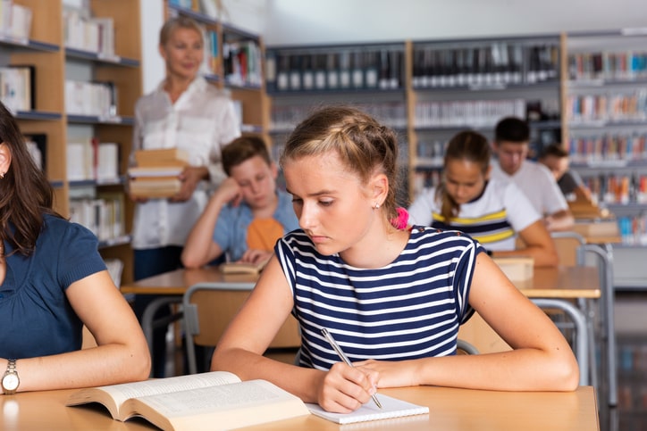 Female student completes fun worksheets for middle school.
