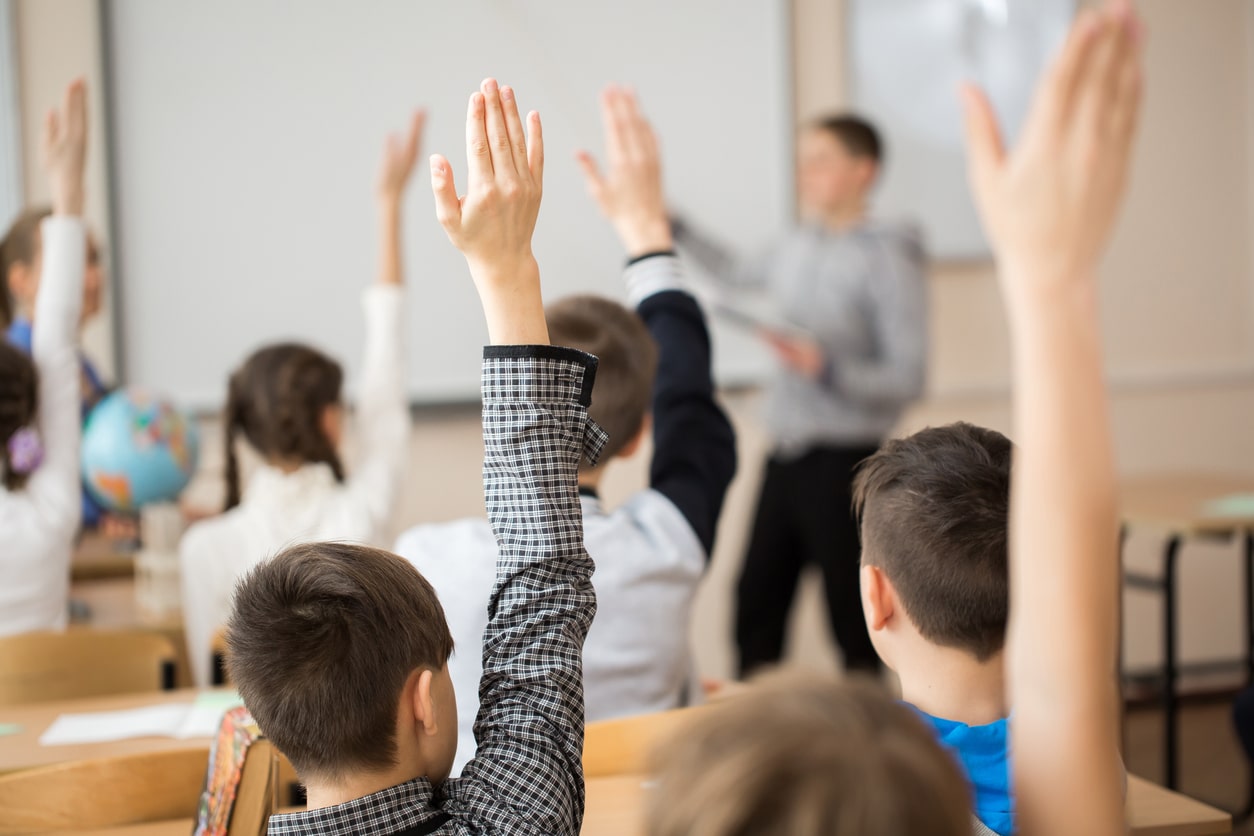 Class raises their hands to ask questions during the lesson plan procedures.