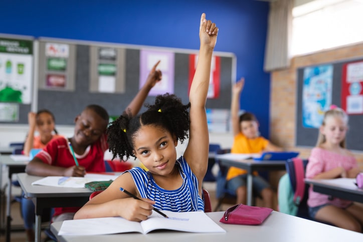 Elementary school student raises her hand before speaking in class. 5 Golden Rules for the Classroom 