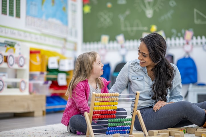 Special education teacher helps child in class. Collaboration between general and special education teachers.