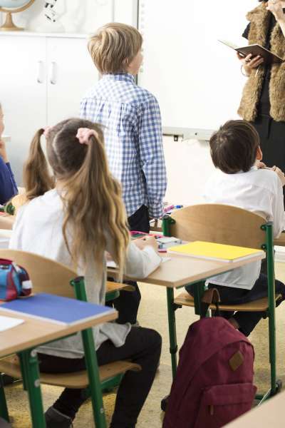 students looking toward a teacher in a classroom