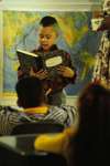 Boy reading to class with map